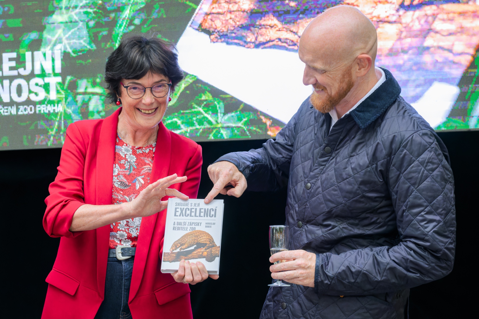 The godparents of Breakfast with Her Excellency, the new book by Prague Zoo’s director Miroslav Bobek - British Ambassador Matt Field and the President of the Czech Academy of Sciences Eva Zažímalová – launched it in the style of Jane Goodall, i.e. by symbolically rubbing the book’s cover with a drop of champagne so as not to damage it. Photo Petr Hamerník, Prague Zoo